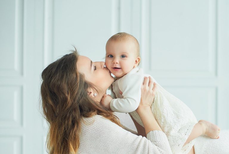 Beautiful young mother with baby girl in arms